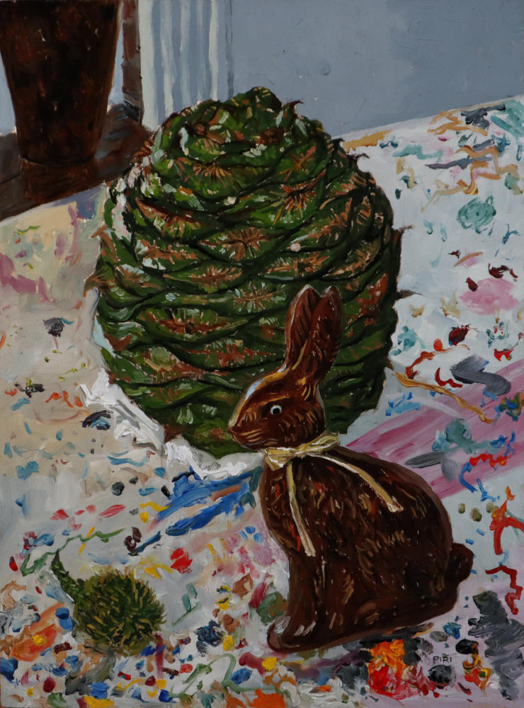 Still life oil painting, featuring Work in progress of a large bunya cone, a tiny bunya cone, and chocolate rabbit decoration. They are sitting on a table covered in different coloured paint splatters and marks. Behind this is a white wall with a bench and part of a large brown vase.